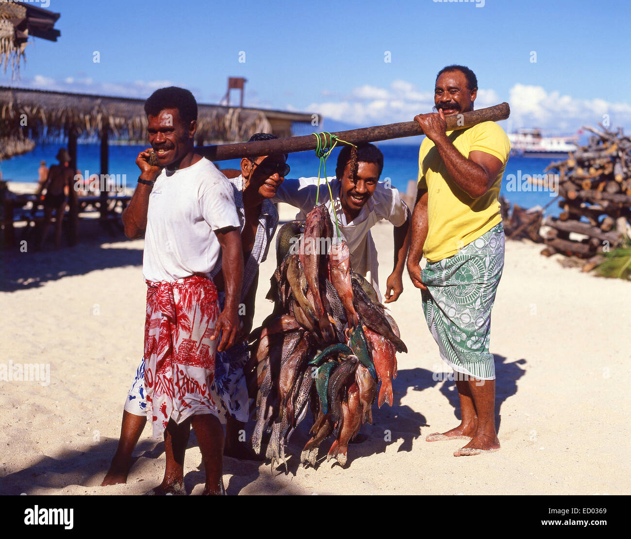 Gli uomini locali con pesce pescato, Beachcomber Resort isola in isola di Beachcomber, Isole della Mamanuca, Viti Levu, Repubblica delle Isole Figi Foto Stock