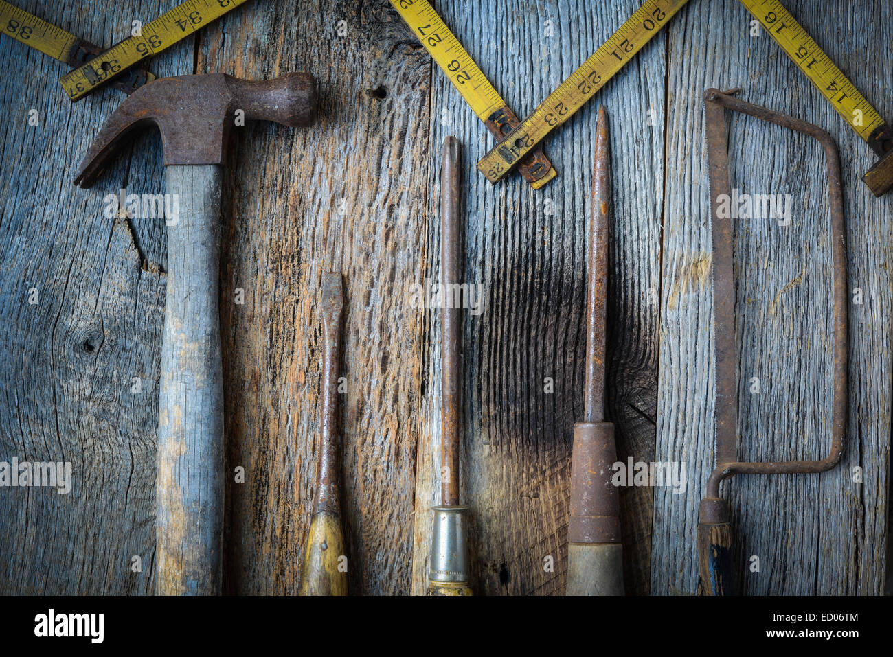 Martello, cacciavite, sega a mano e nastro di misurazione su legno rustico sfondo Foto Stock