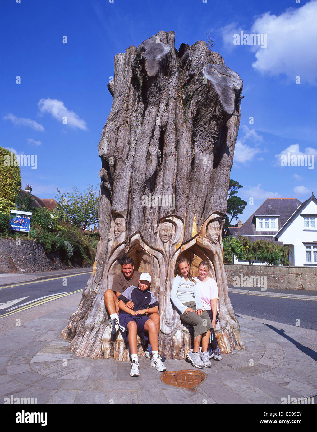 Famiglia seduta nel Grande Albero scolpito, Paignton, Tor Bay, Devon, Inghilterra, Regno Unito Foto Stock