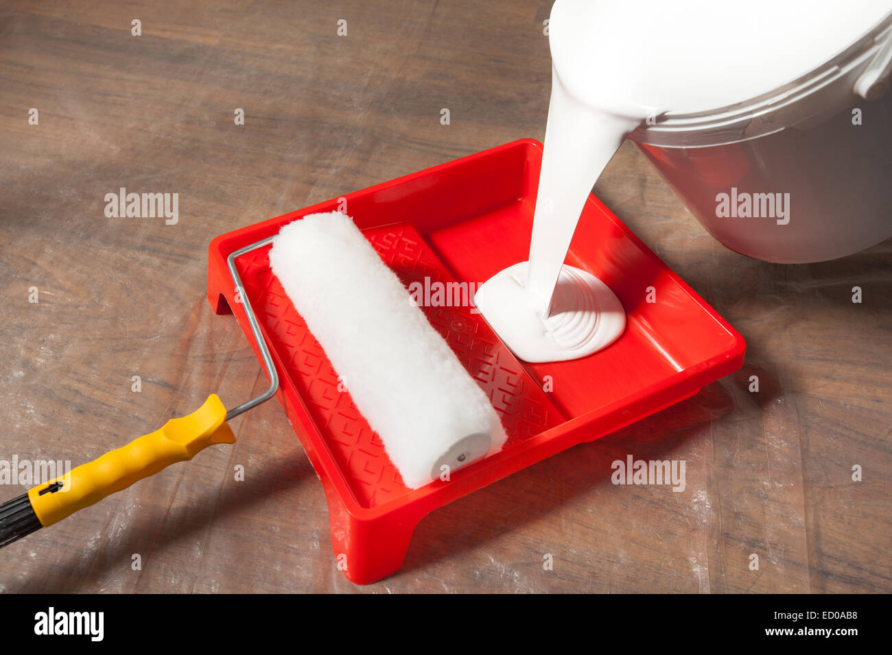 La preparazione per la verniciatura, versando la vernice in un vassoio. Foto Stock