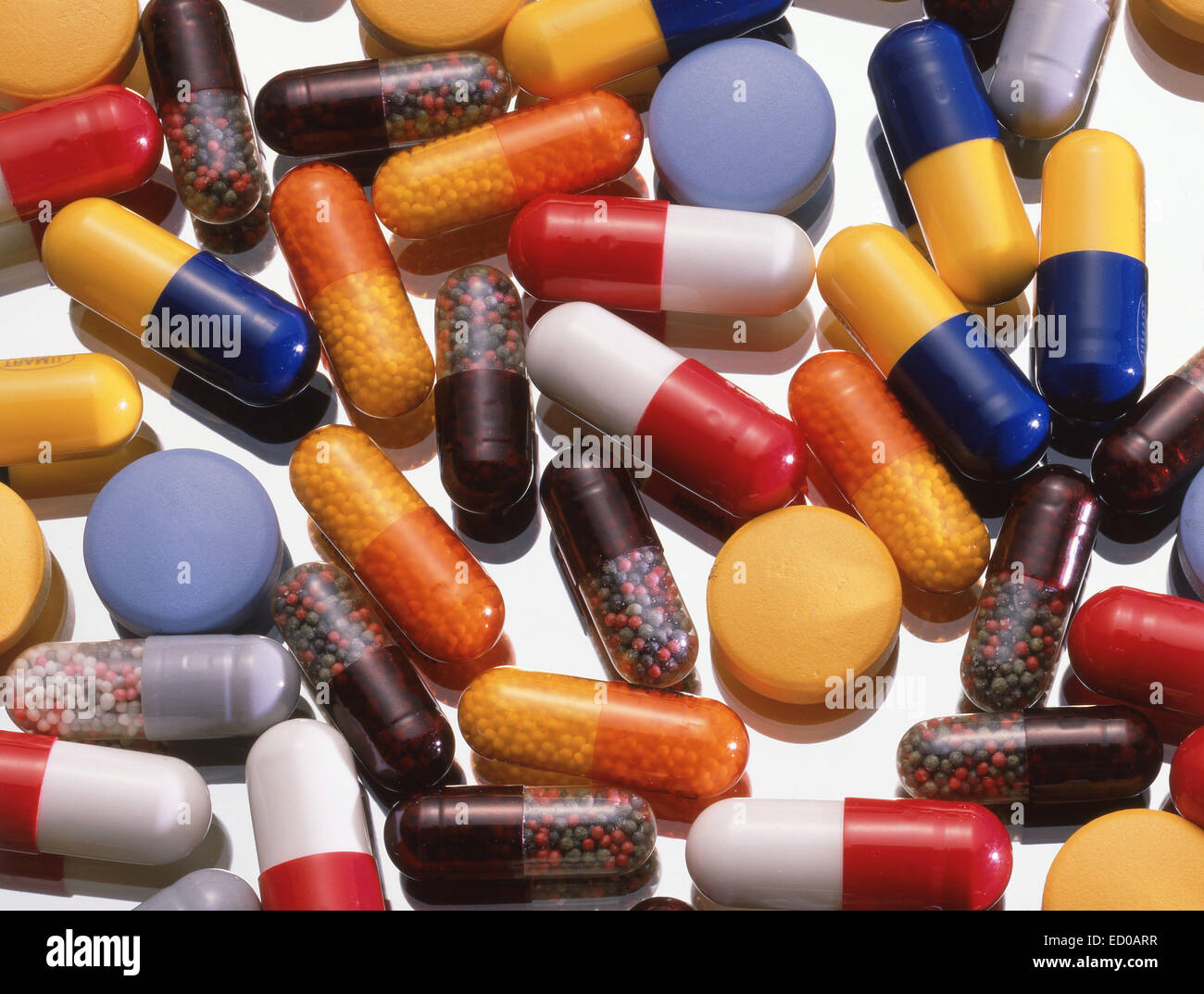Un assortimento di pillole, capsule e compresse su sfondo di vetro Foto Stock