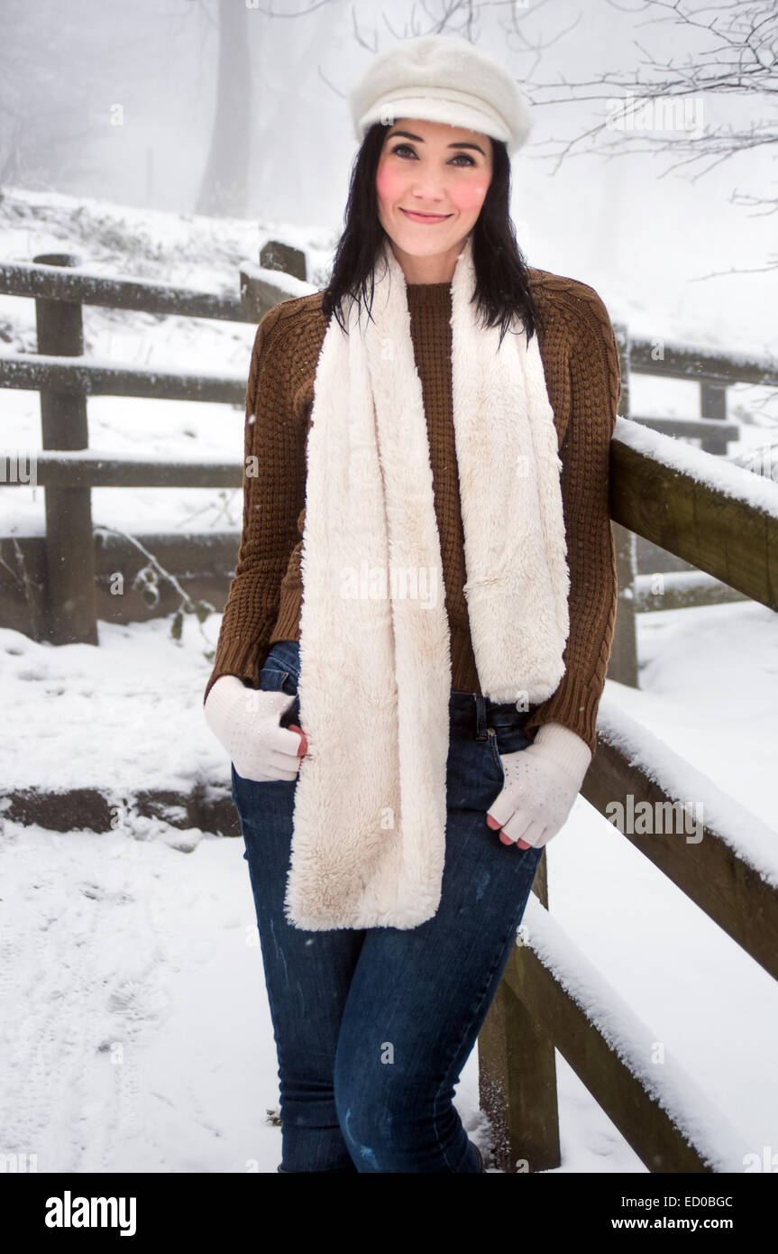 Donna che indossa la maglieria godendo di neve Foto Stock