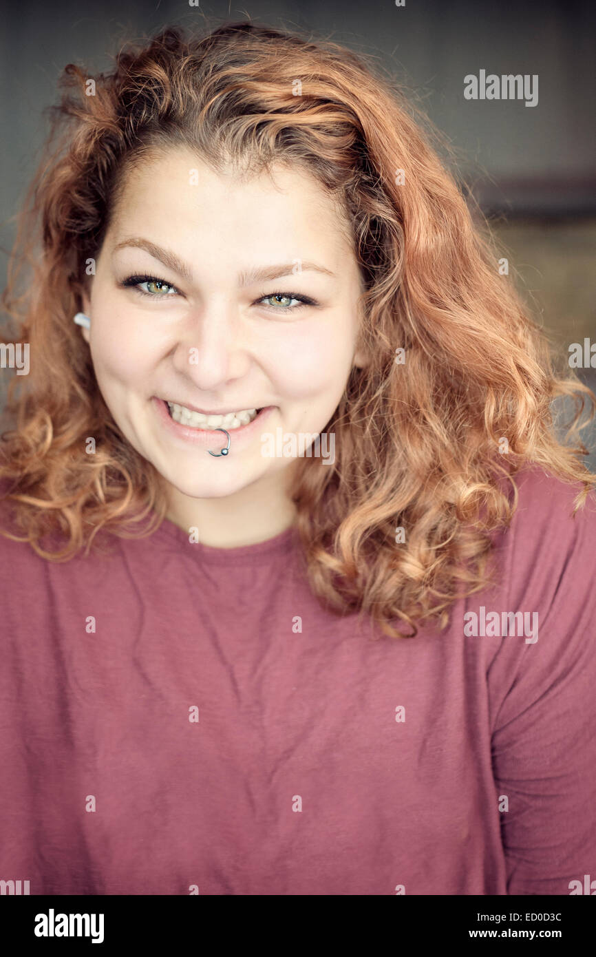 Sorridente giovane donna con anello a labbro Foto Stock