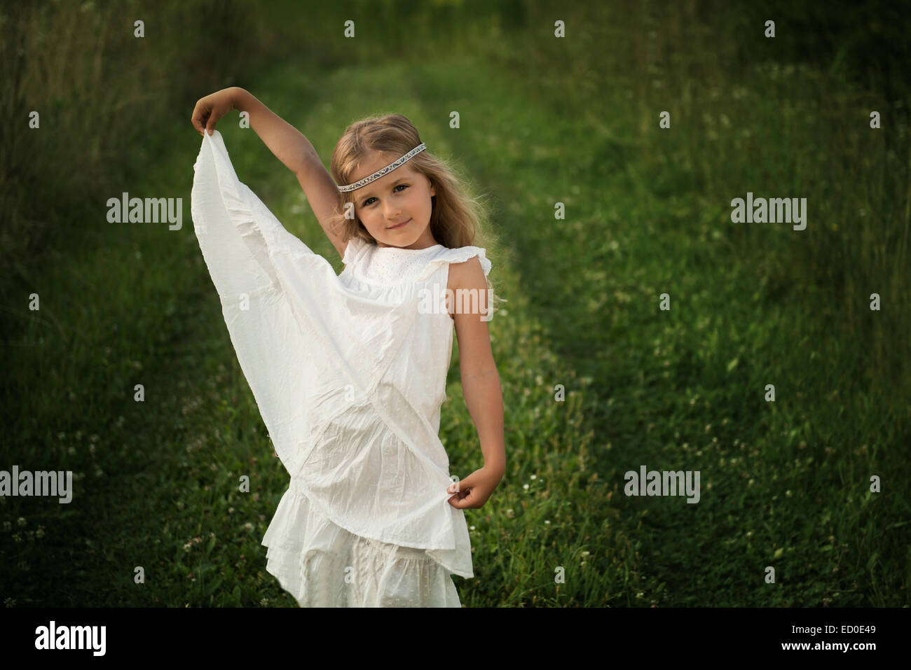 Ragazza giovane (4-5) in posa lungo abito bianco Foto Stock