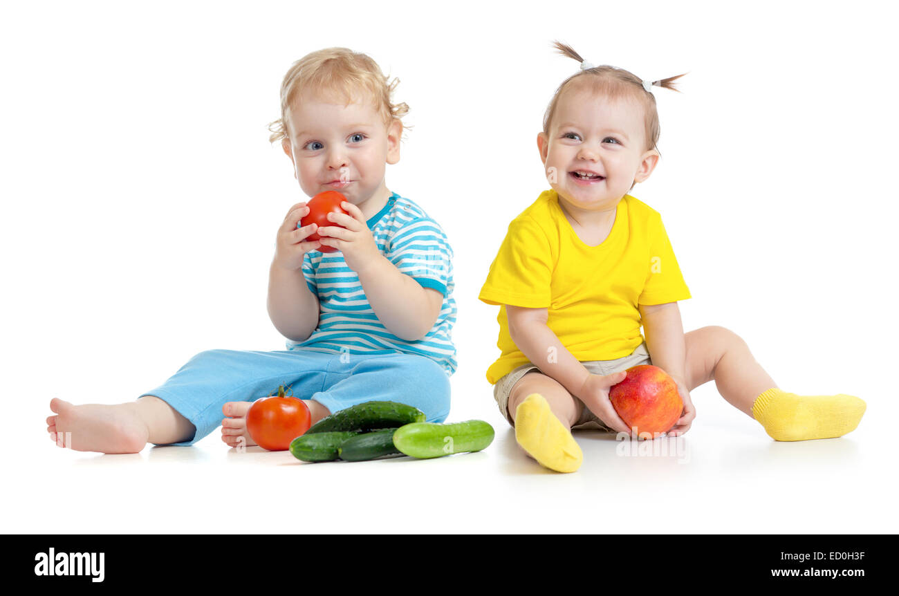 I bambini a mangiare frutta e verdura isolato su bianco Foto Stock