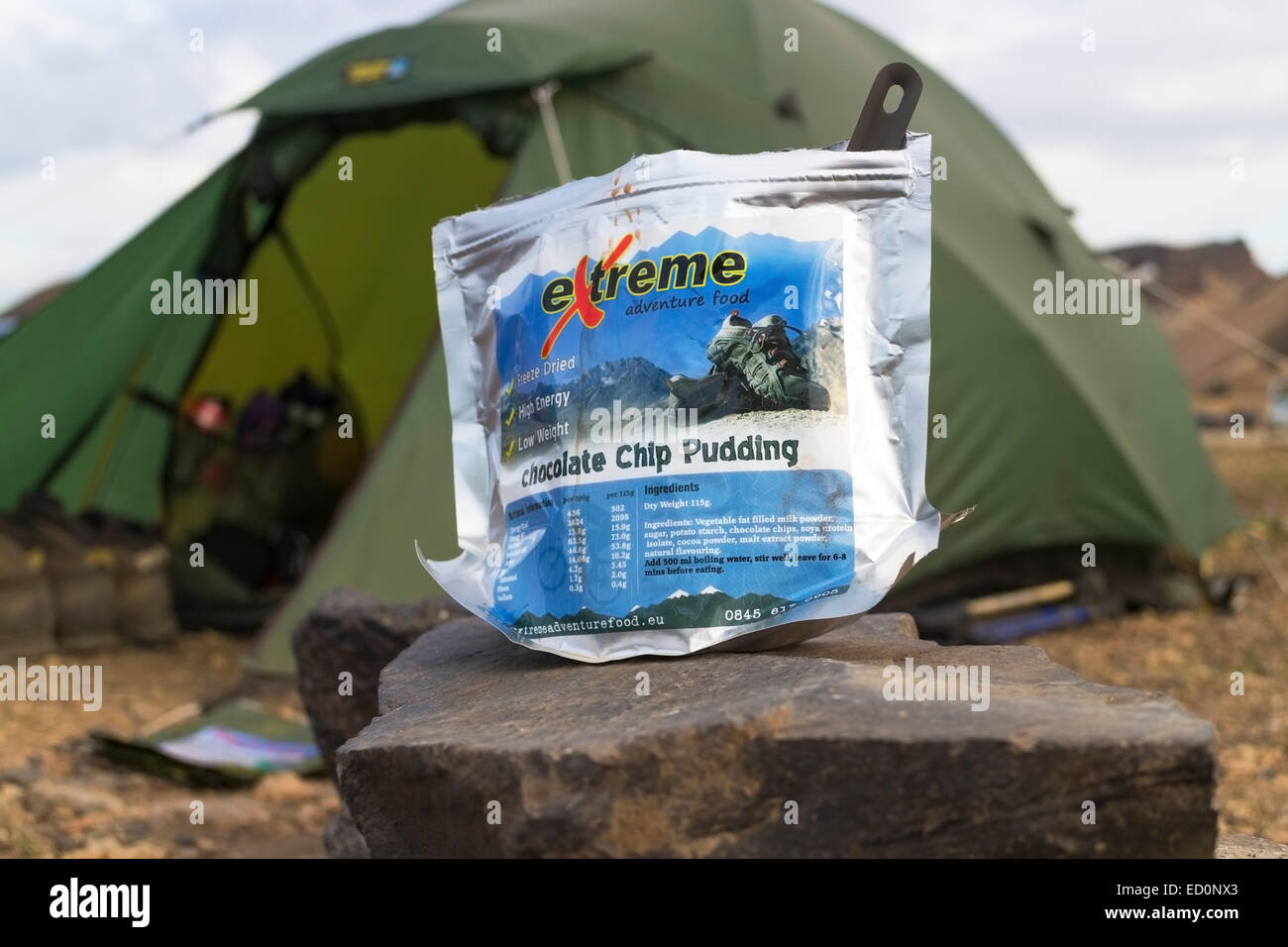 Alta energia liofilizzata pasto in piedi su una roccia per ricostituire con la tenda dietro, Islanda Foto Stock