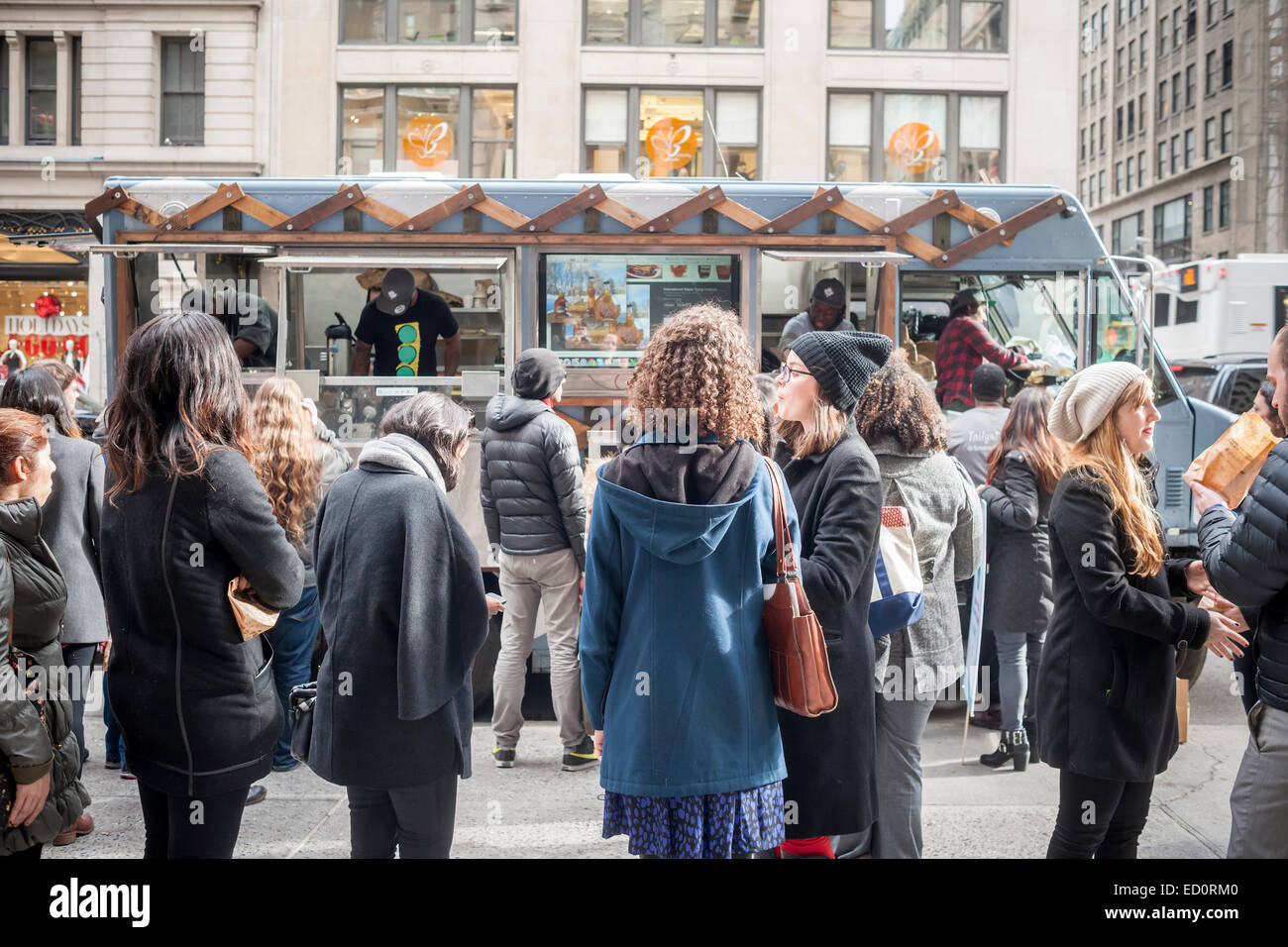 Orde di foodies in coda fino al Snowday carrello in New York il Mercoledì, Dicembre 17, 2014 per celebrare il National sciroppo d'acero giorno, collaborando con il Canadese di sciroppo di acero, con campioni gratuiti di vari piatti tra cui maple formaggio alla griglia e di acero di carne di maiale affumicata cursori. Il socialmente sostenibile cibo carrello, parte di guidare il cambiamento, corre un re-entry programma impiegando l'ex carcere. (© Richard B. Levine) Foto Stock