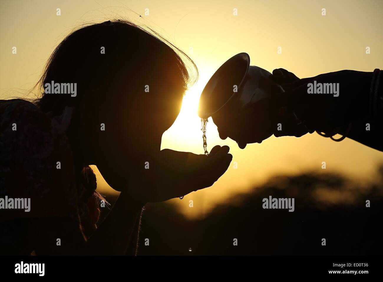 Madre indiana dando acqua a sua figlia India Foto Stock