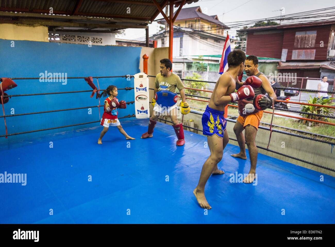 Bangkok, Bangkok, Thailandia. 23 dic 2014. Pugili spar e allenarvi nella palestra Kanisorn in Bangkok. La boxe Kanisorn palestra è una piccola palestra lungo la Wong Wian Yai - Samut Sakhon binari del treno. I giovani dalla vicina europee entrano in palestra per saperne di thai boxing. Muay Thai (Muai Thai) è un misto di arte marziale sviluppato in Thailandia. La Muay Thai è diffuso a livello internazionale nel ventesimo secolo quando i boxer tailandese ha sconfitto gli altri ben noti boxer. Un campionato professionale è disciplinata dal mondo Muay Thai consiglio. La Muay Thai è spesso visto come un modo per uscire dalla povertà per giovani tailandesi. Mua Foto Stock