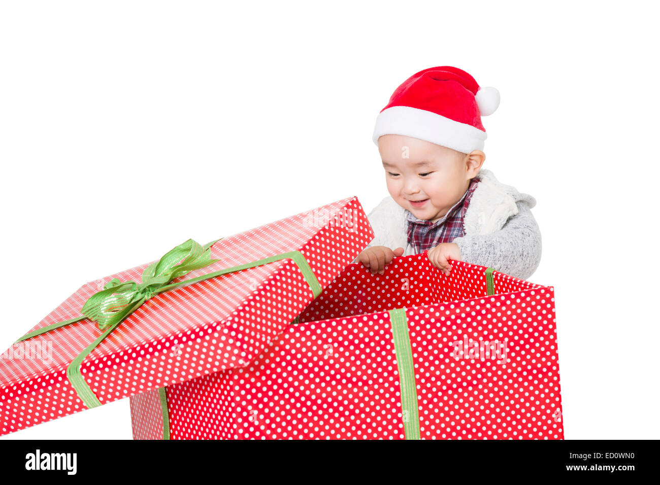 Carino baby scartare un regalo di Natale Foto stock - Alamy