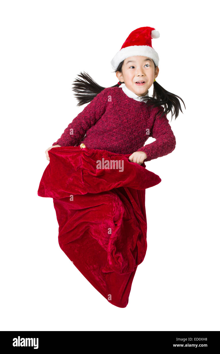 Happy girl jumping in grande Santa in borsa Foto Stock