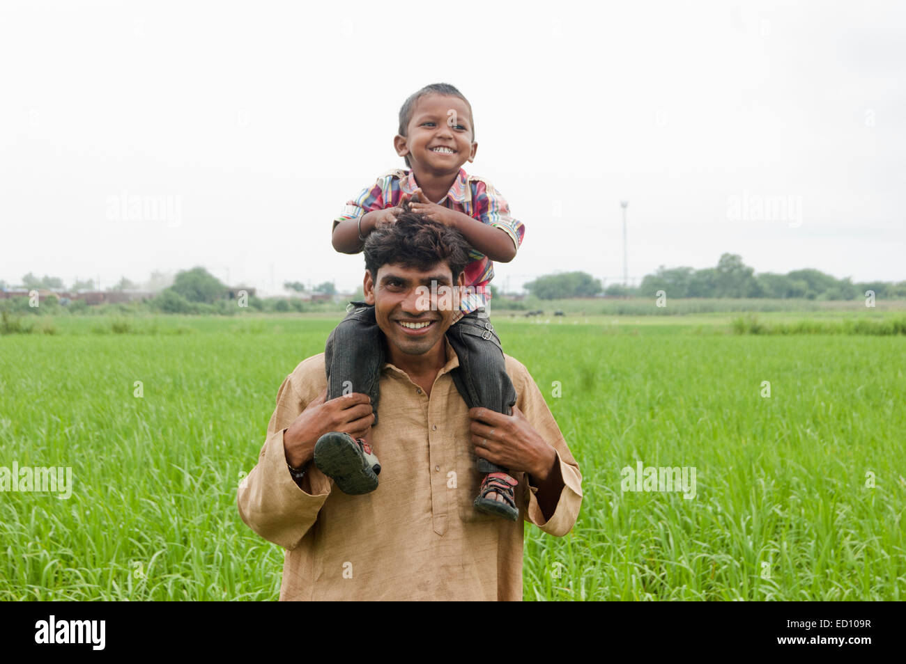 Rurale indiano padre con bambino divertimento sul campo Foto Stock