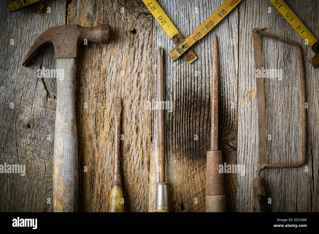 Martello, cacciavite, sega a mano e nastro di misurazione su legno rustico sfondo Foto Stock
