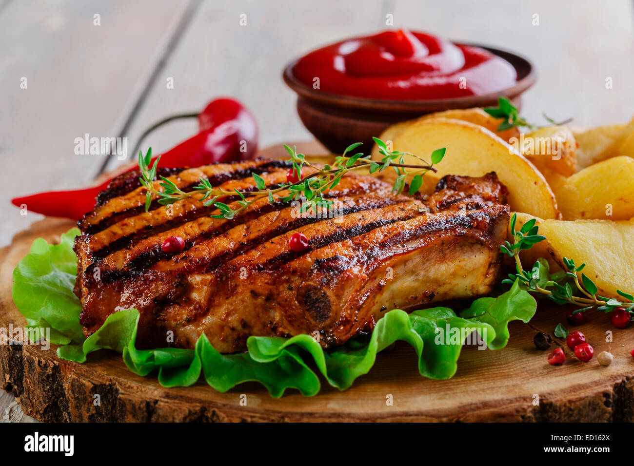 Bistecca alla griglia sull'osso con patate Foto Stock