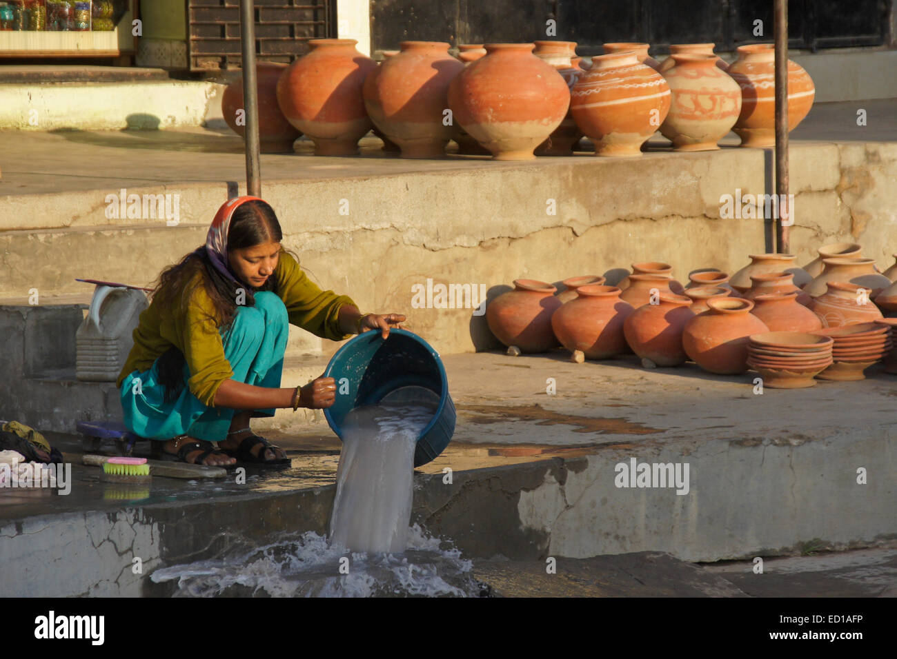 Ragazza facendo servizio lavanderia e vendita di ceramiche, Poshina, Gujarat, India Foto Stock