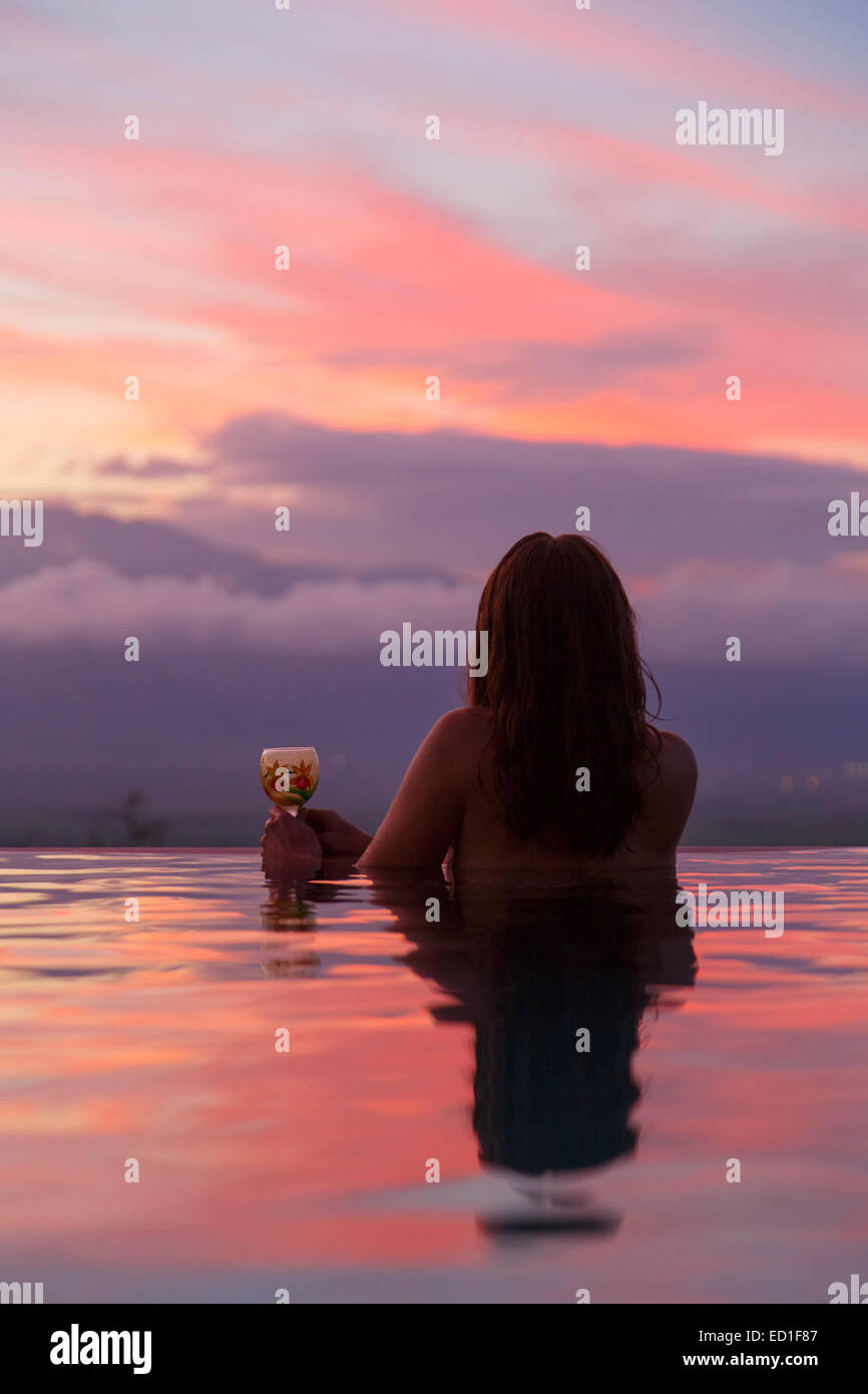 Un visitatore godersi il tramonto da una piscina all'infinito, Maui, Hawaii. (Modello rilasciato) Foto Stock
