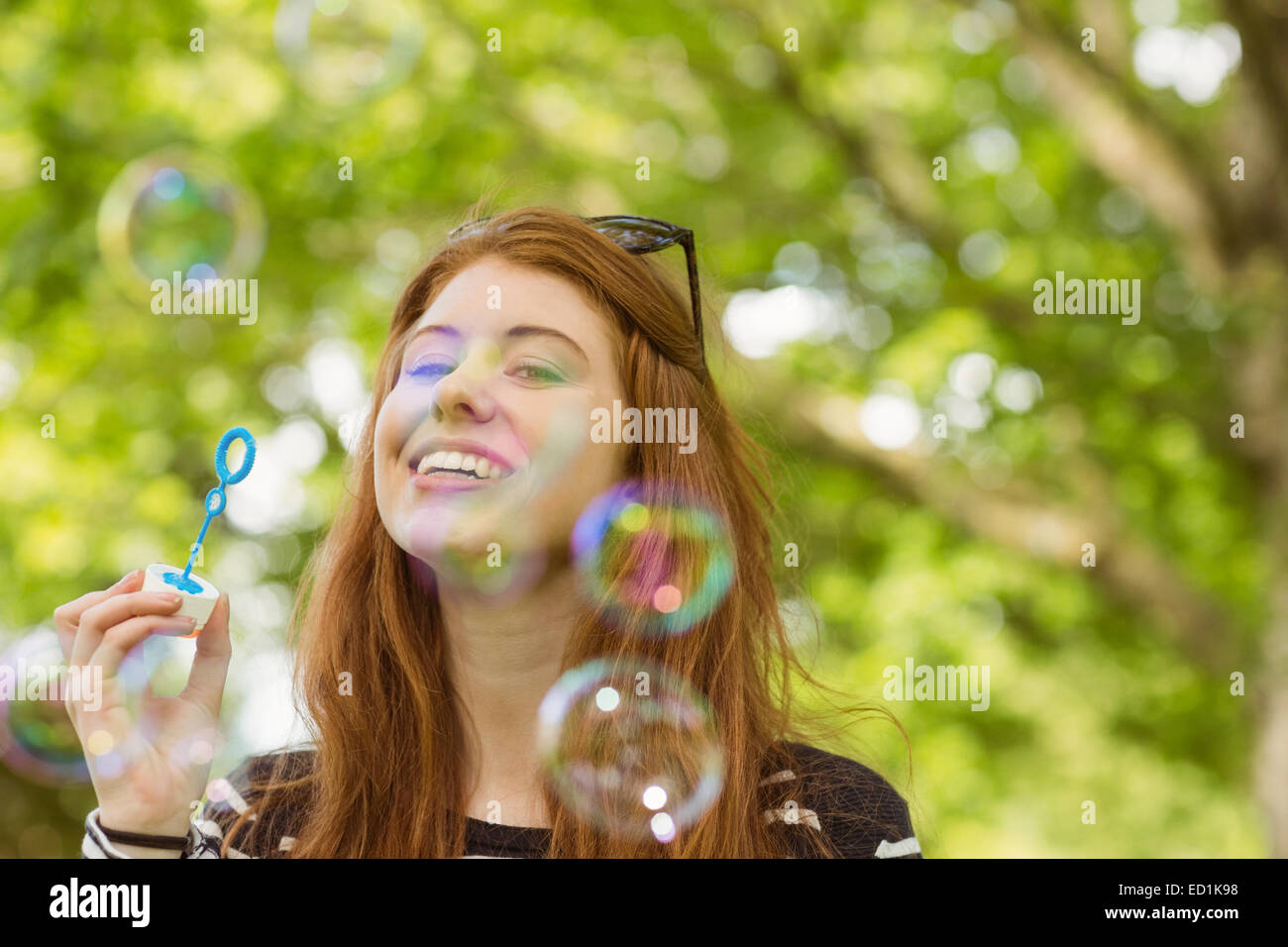 La donna a soffiare bolle in posizione di parcheggio Foto Stock
