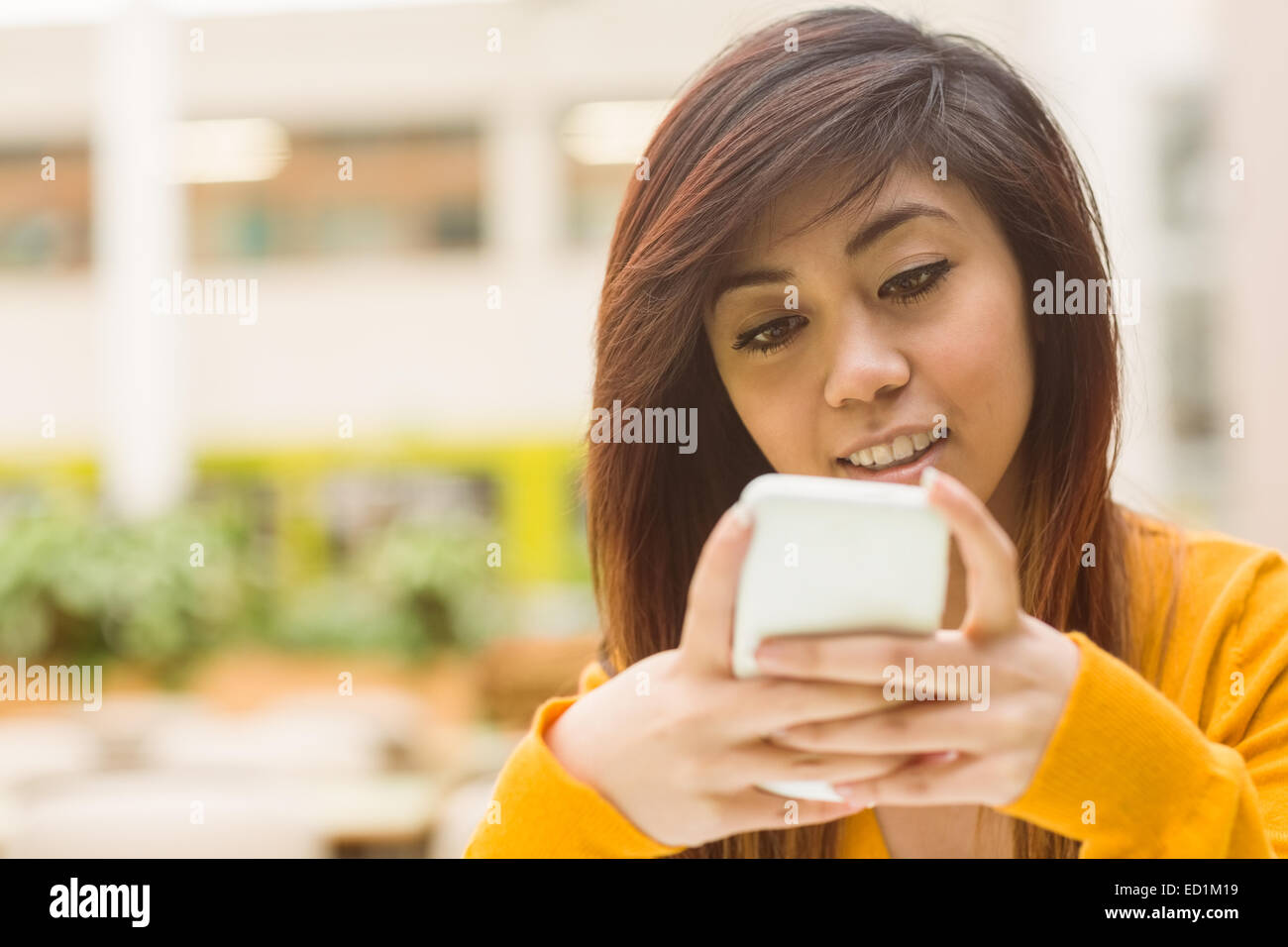 Bella giovane donna alla messaggistica di testo Foto Stock