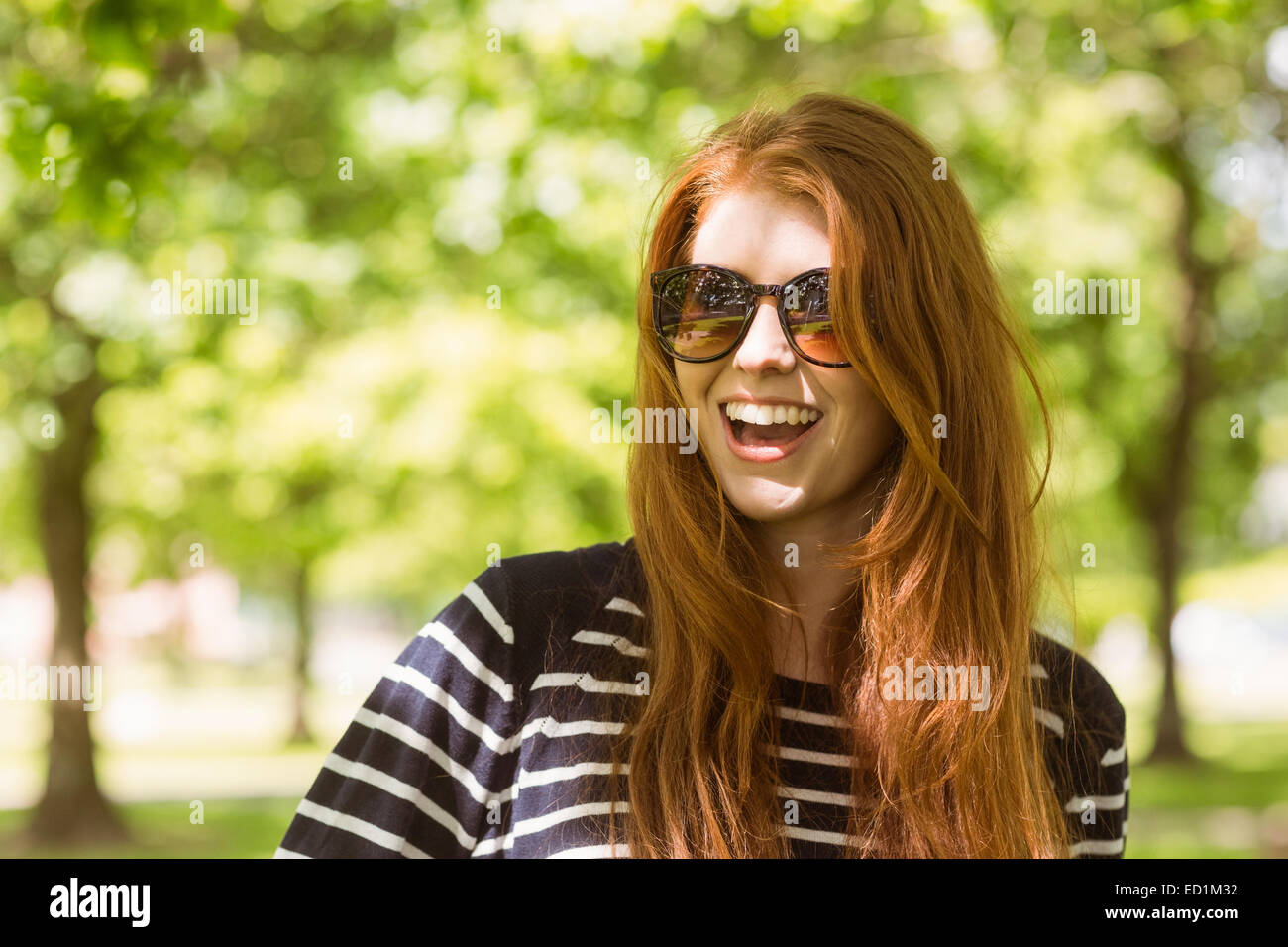 Felice bella donna che indossa gli occhiali da sole Foto Stock