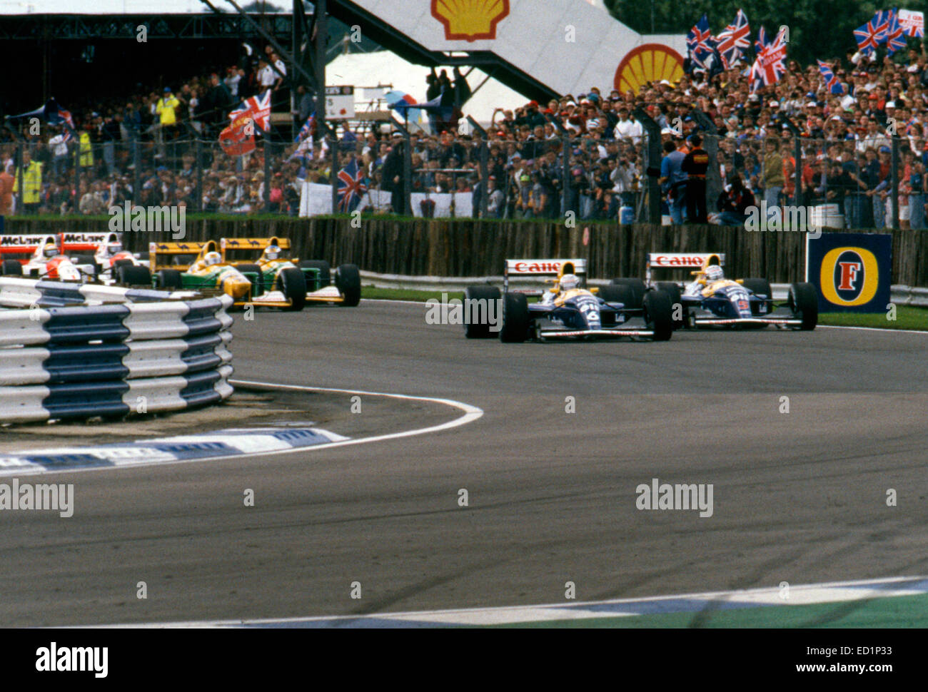 1992 Gran Premio di Gran Bretagna a Silverstone. Patrese conduce Mansell nella loro Williams FW14B in un ceduo, 1° giro. Foto Stock