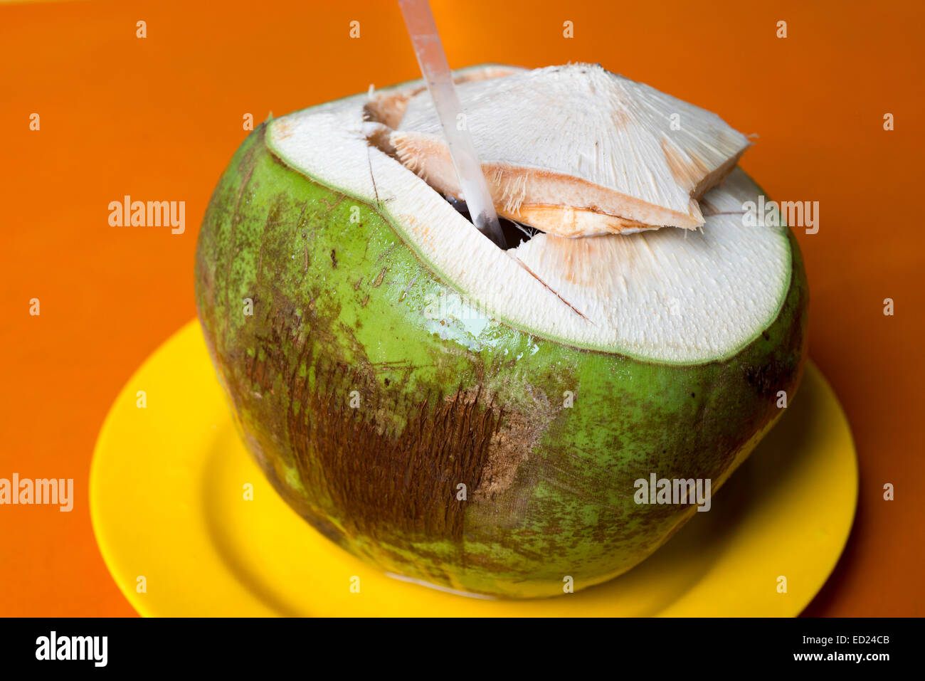 Succosa fresche noce di cocco verde servito sulla piastra di colore giallo Foto Stock