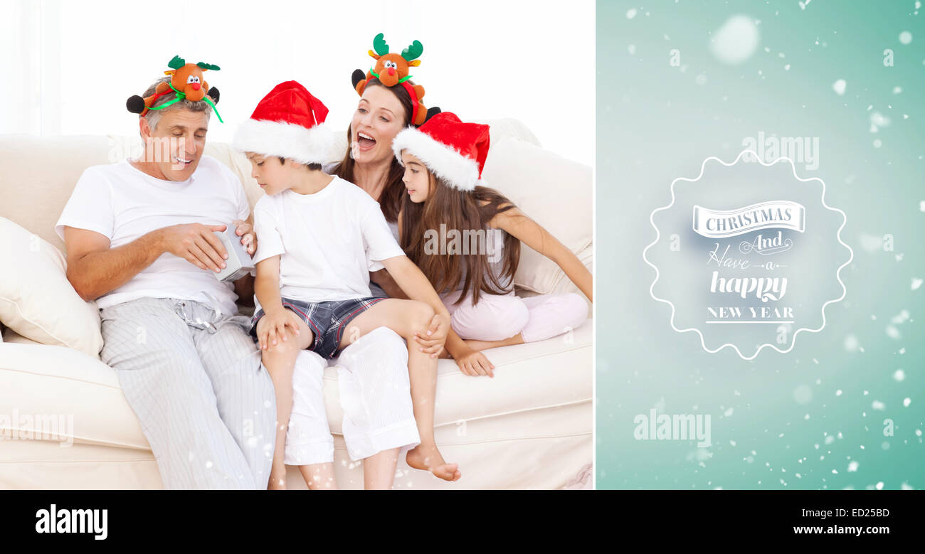 Immagine composita della famiglia il giorno di Natale guardando la loro presenta a casa Foto Stock
