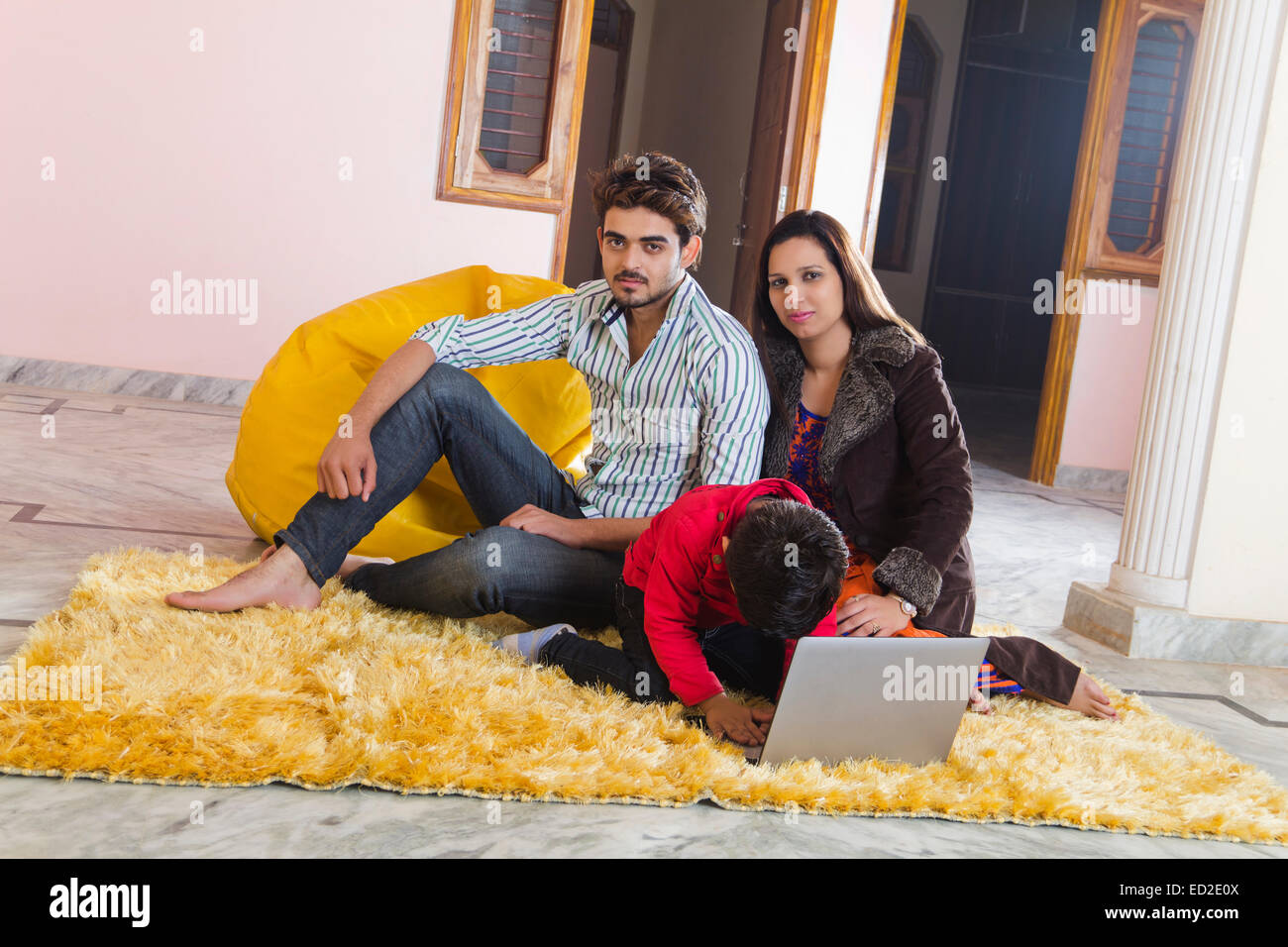 Indian genitori e figlio home computer portatile funzionante Foto Stock
