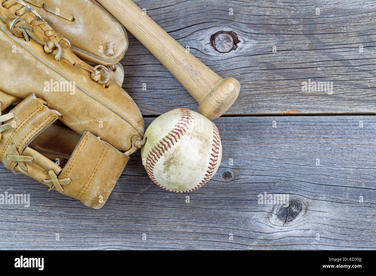 L'immagine orizzontale di una parziale vecchio guanto indossato, bat e utilizzato il baseball su legno rustico Foto Stock