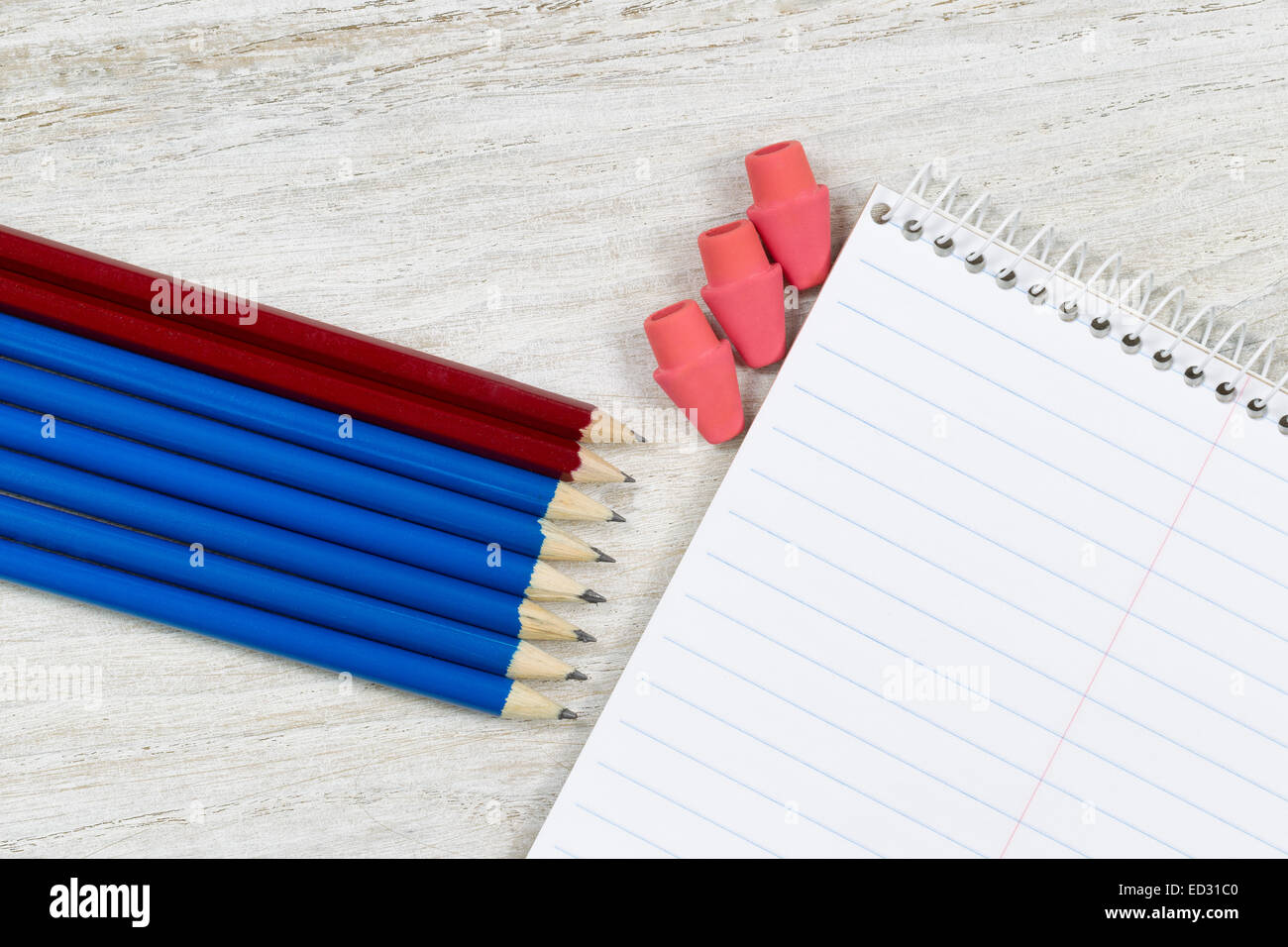 Punte a matita e cancellatori puntando ad una spirale vuota notepad sul rustico in legno di colore bianco Foto Stock