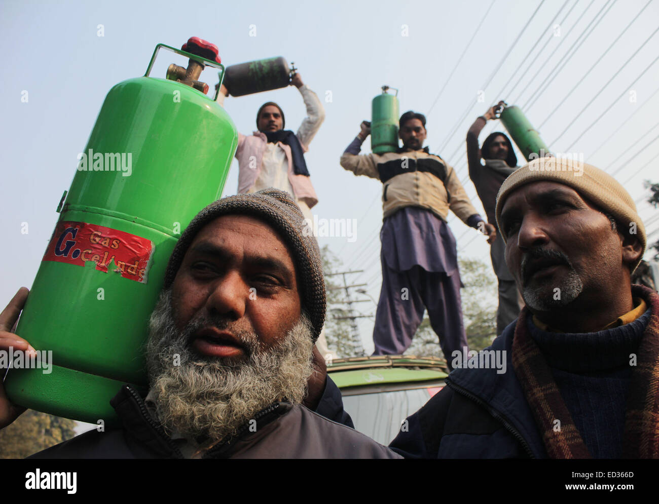 Lahore, Pakistan. 24 dicembre, 2014. Il pakistan Rickshaw driver e membri della Awami Rickshaw Unione chant slogan contro il prezzo escursione sul gas di petrolio liquefatto (GPL) e la penuria di gas naturale compresso (CNG) durante una manifestazione di protesta a Lahore. Credito: Rana Sajid Hussain/Pacific Press/Alamy Live News Foto Stock