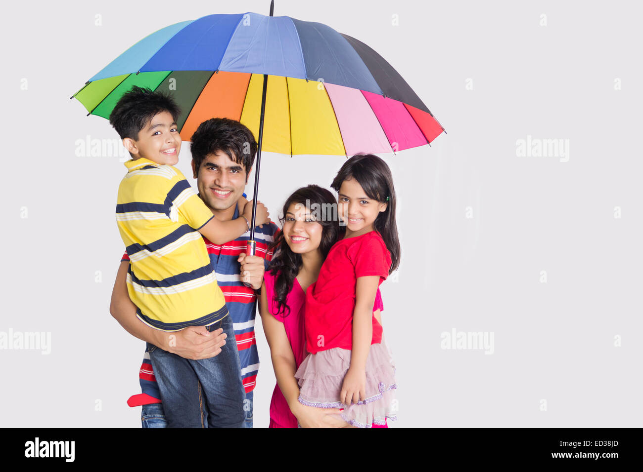 Indian genitori e bambini ombrello di protezione dalla pioggia Foto Stock