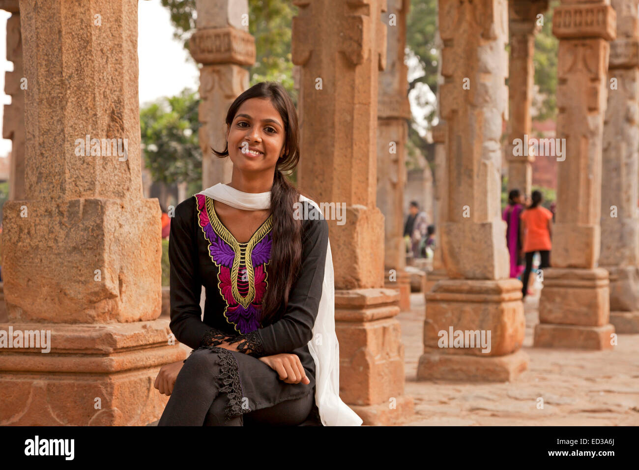 Giovane donna indiana a lui il chiostro delle colonne della Quwwat ul-Islam moschea, Qutb complessa, Sito Patrimonio Mondiale dell'UNESCO a Delhi, indi Foto Stock