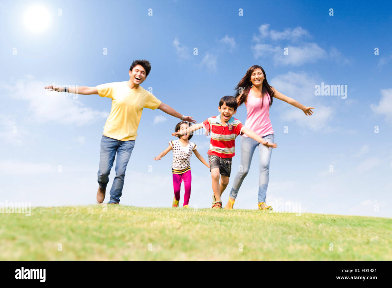 Indian genitori con parco per bambini in esecuzione Foto Stock