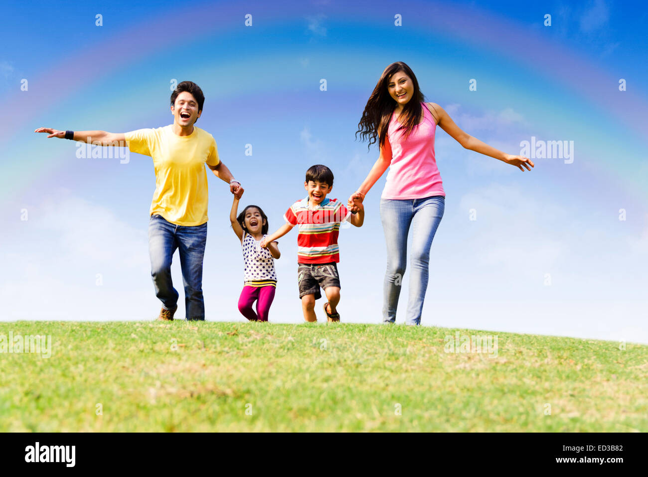 Indian genitori con parco per bambini in esecuzione Foto Stock