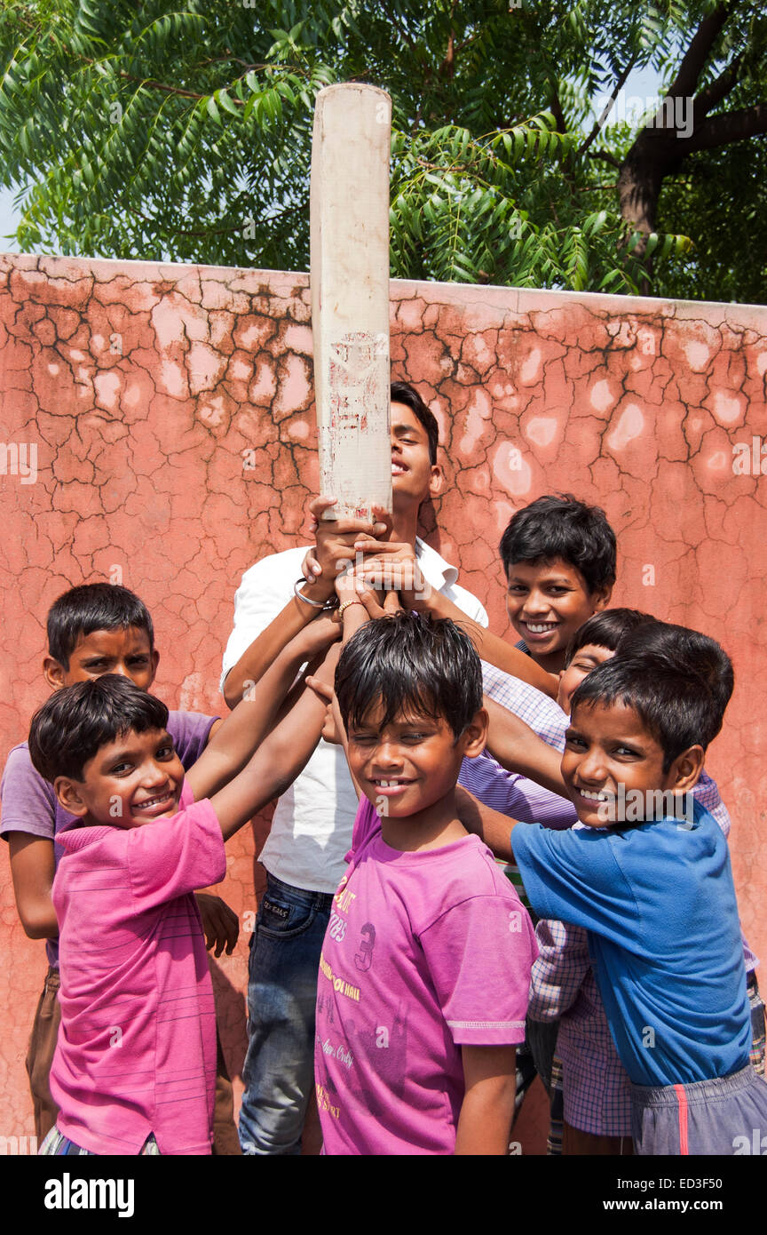 Rurale indiano bambini gruppo di ragazzi giocare a cricket Foto Stock