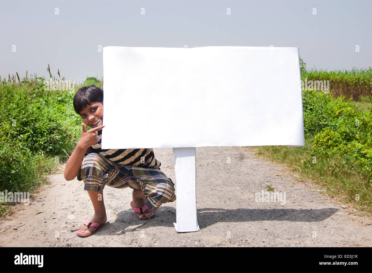 1 bambino rurale ragazzo di strada sterrata che mostra la Bacheca Foto Stock