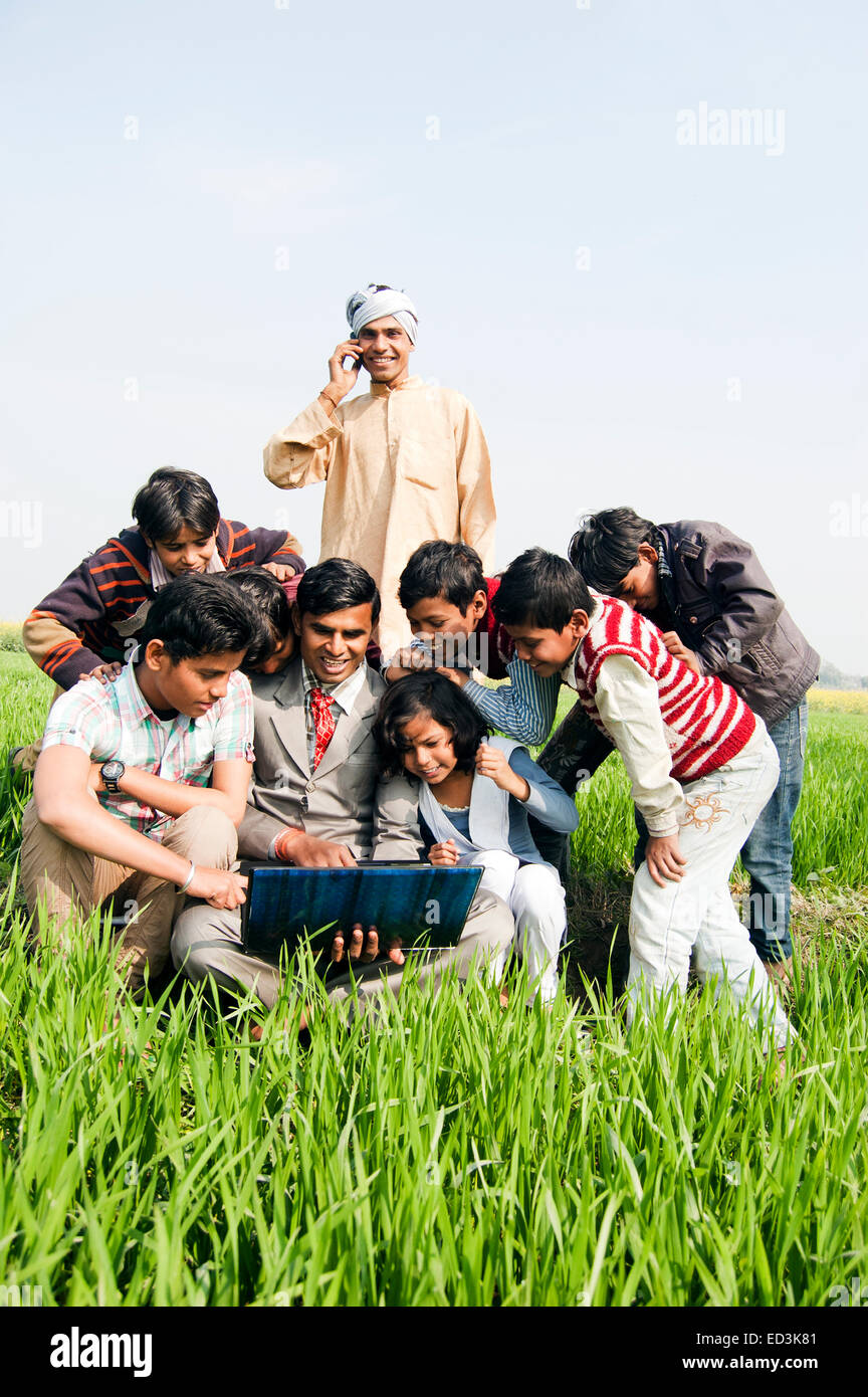 Rurale indiano agricoltore famiglia con uomo di affari di lavoro portatile Foto Stock