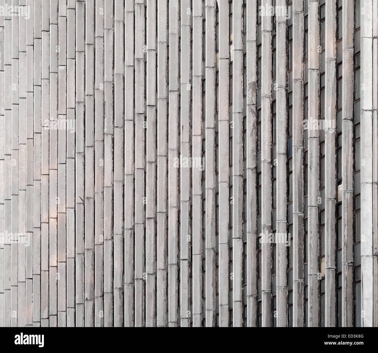 Abstract architettura dello sfondo. Parete in cemento con linee verticali e windows Foto Stock