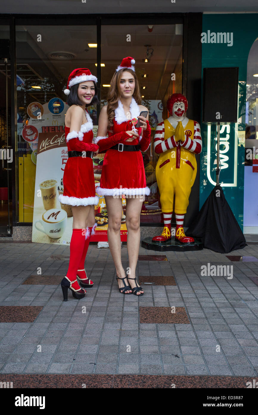 Giovani donne vestito come Santa's aiutanti il giorno di Natale a Bangkok Foto Stock
