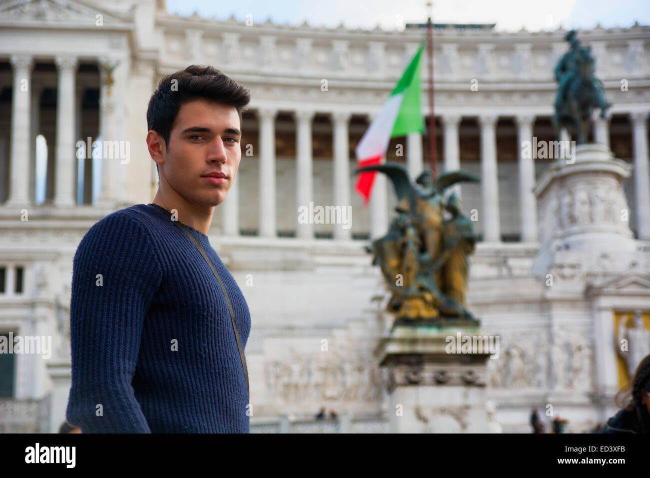 Attraente giovane in Italia a Roma, di fronte al monumento Vittoriano in piedi, guardando la fotocamera Foto Stock