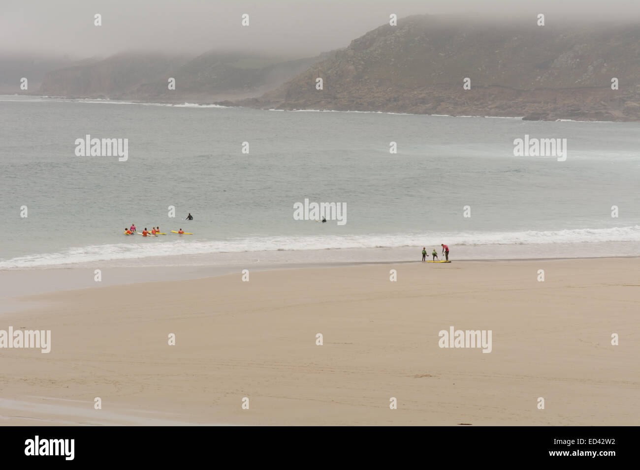 Imparare a fare surf alla scuola di surf sulla spiaggia di Sennen Cove, Cornwall, Inghilterra sui giorni di autunno Foto Stock