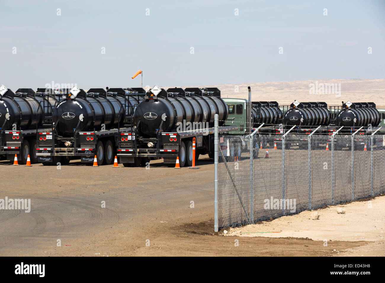 I carrelli di trasporto in Midway Sunset oilfield in Taft, Bakersfield, California, Stati Uniti d'America. A seguito di un inedito e quattro anni di siccità, Bakersfield è ora il più arido città in Stati Uniti d'America, guidati dal cambiamento climatico. Gli americani ancora non riescono a fare il collegamento tra la loro dipendenza da combustibili fossili e il cambiamento climatico. Molti dei pozzi di petrolio in questa area sono state fracked. Foto Stock
