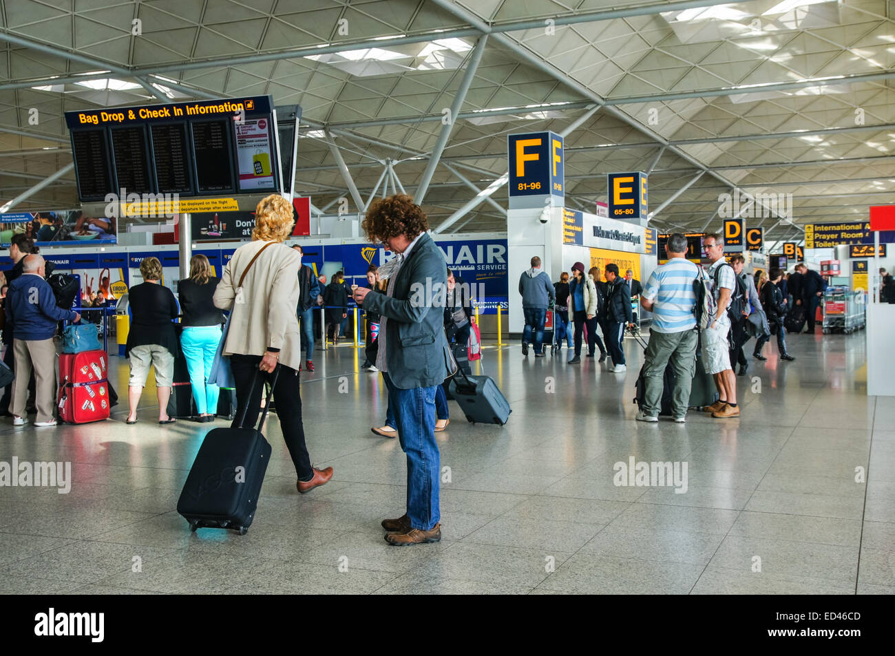Passeggeri e viaggiatori all'aeroporto di Londra Stansted Essex Inghilterra Regno Unito Regno Unito Foto Stock