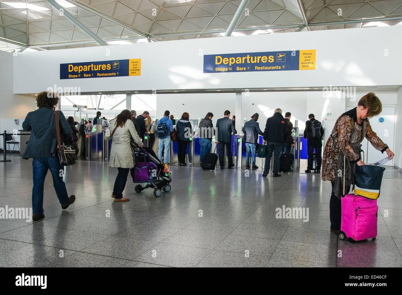 Passeggeri e viaggiatori che attraversano la zona Partenze presso l'aeroporto di Londra Stansted Essex Inghilterra Regno Unito Regno Unito Foto Stock