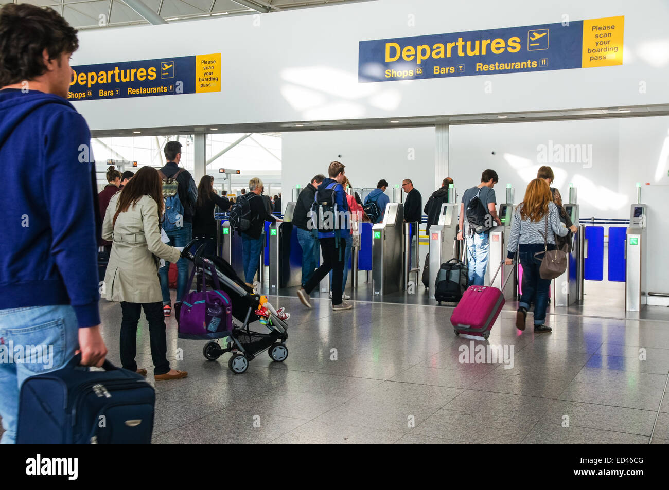 Passeggeri e viaggiatori che attraversano la zona Partenze presso l'aeroporto di Londra Stansted Essex Inghilterra Regno Unito Regno Unito Foto Stock