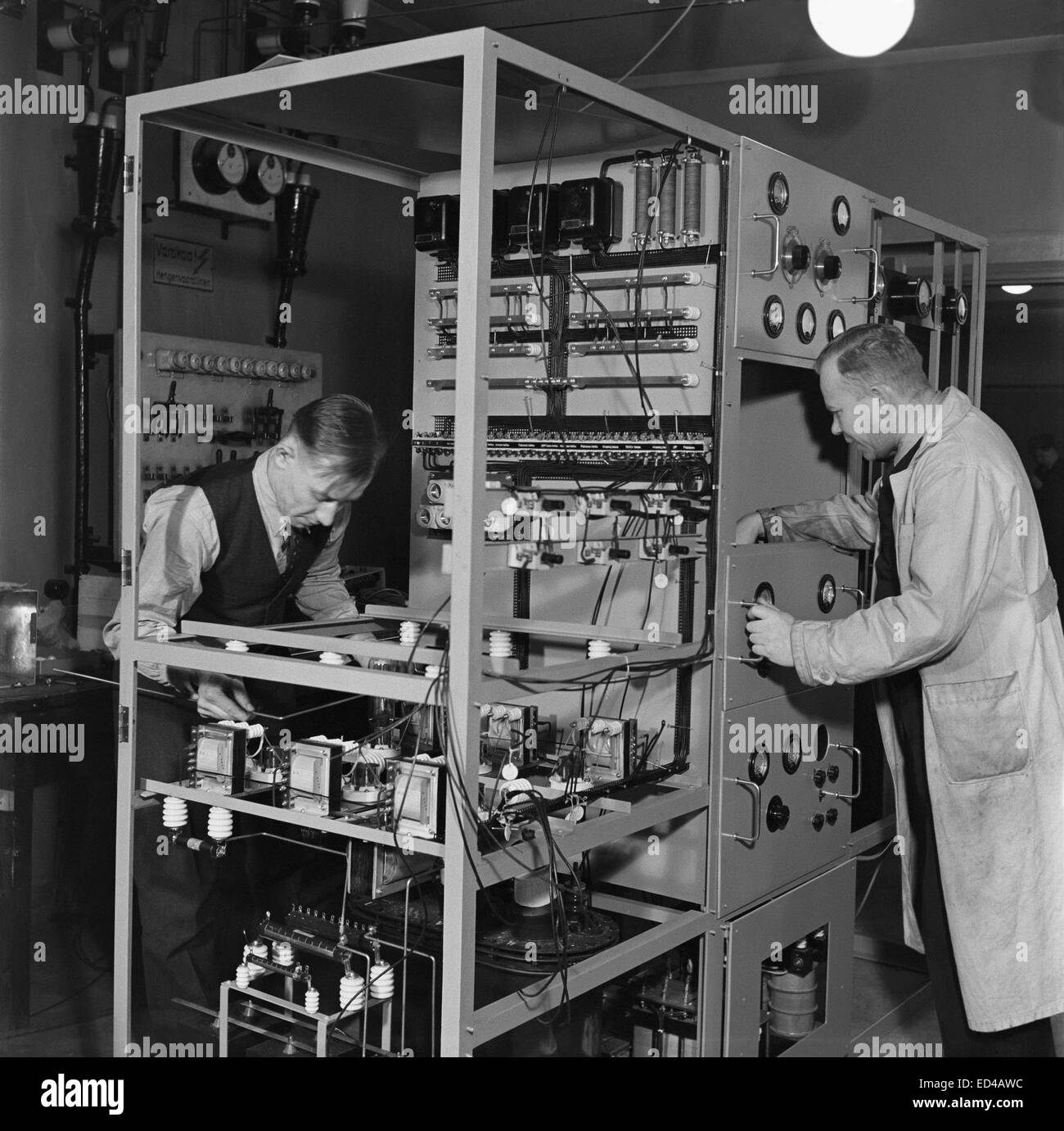 Due meccanici fabbricazione di un 1 kW intermedio trasmettitore di onde in Yleisradio's workshop, ca. 1938. Foto Stock