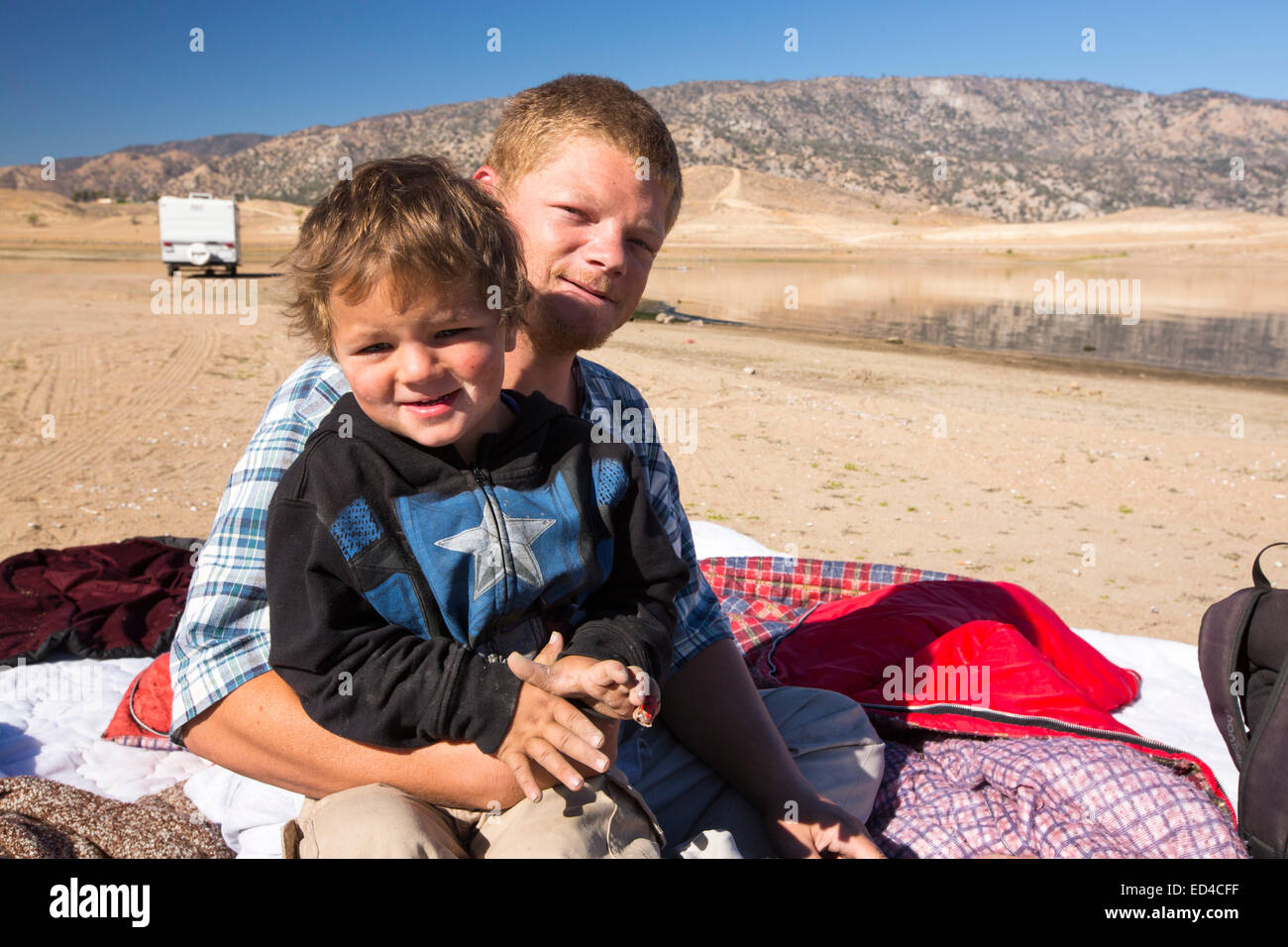 Un padre e figlio camping sul fondo del lago di Lago Isabella vicino a Bakersfield, est della California valle centrale che è a meno di 13% di capacità dopo quattro anni di siccità devastanti. Il serbatoio è scesa così bassa che il livello di acqua è al di sotto del tubo di uscita. Foto Stock