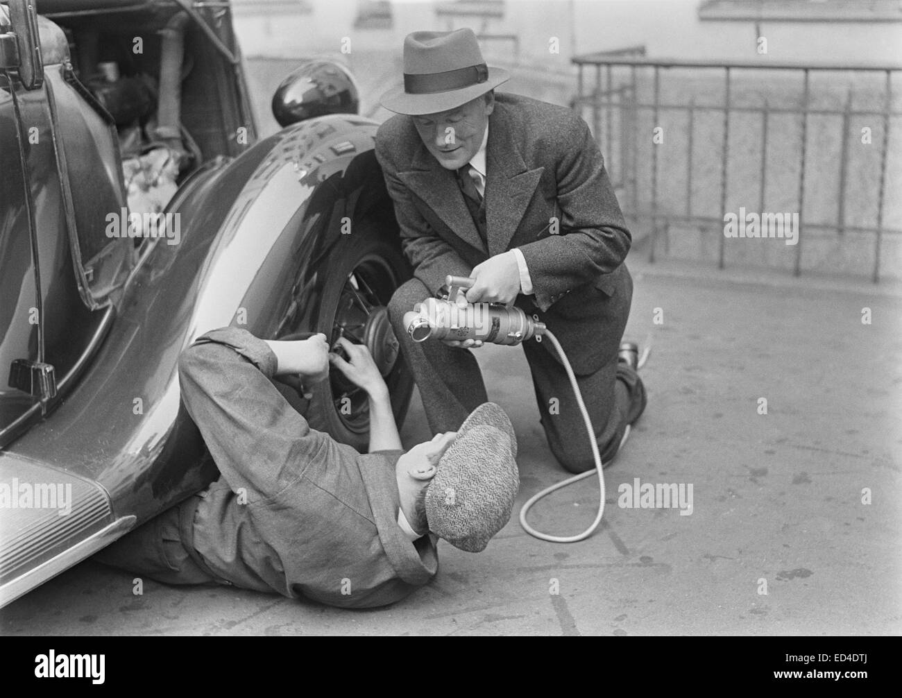 Radio reporter Alexis af Enehjelm intervistando un uomo che fissa una vettura, 1930s. Foto Stock