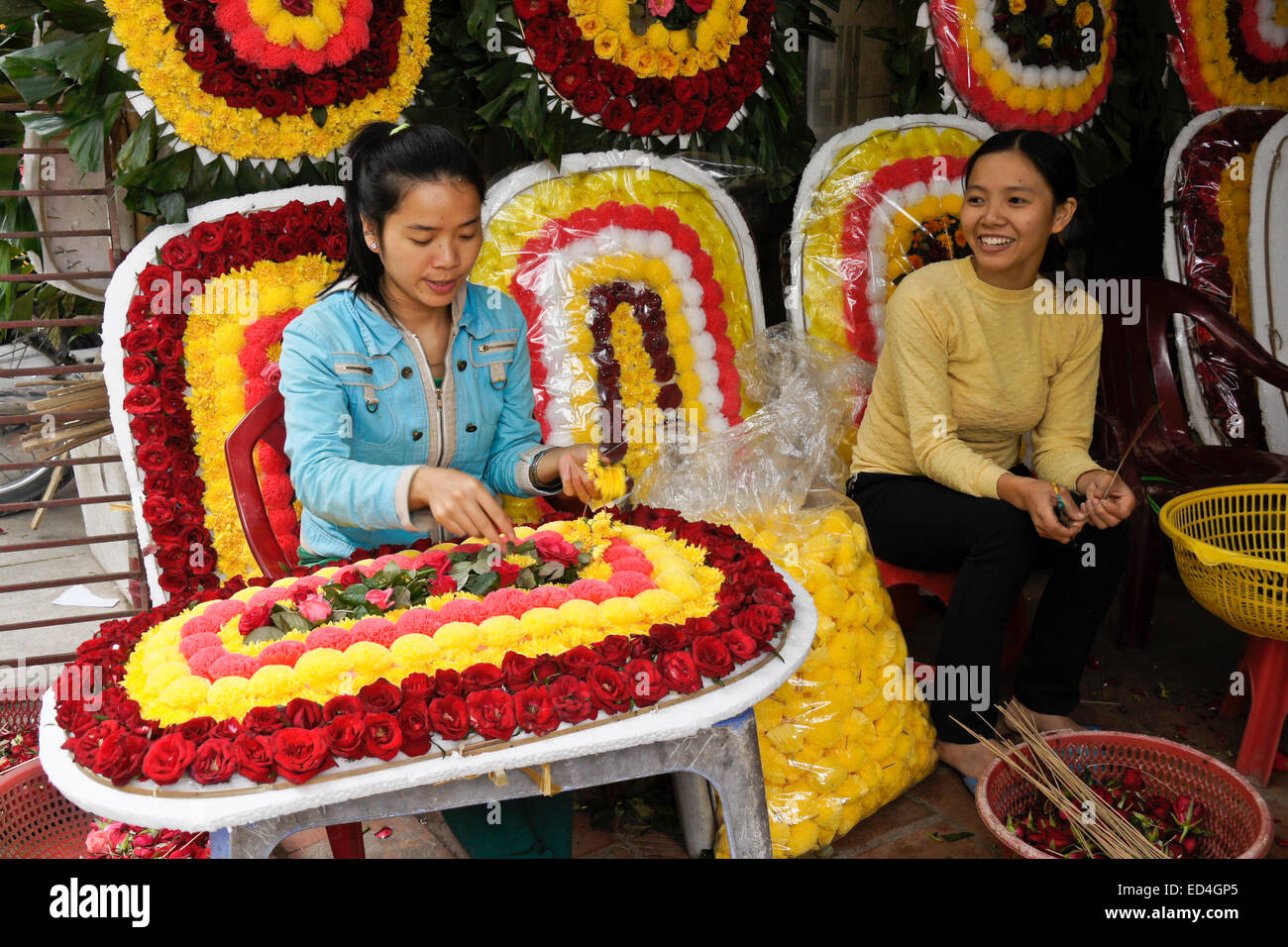 Ragazze rendendo composizioni floreali, Hanoi, Vietnam Foto Stock