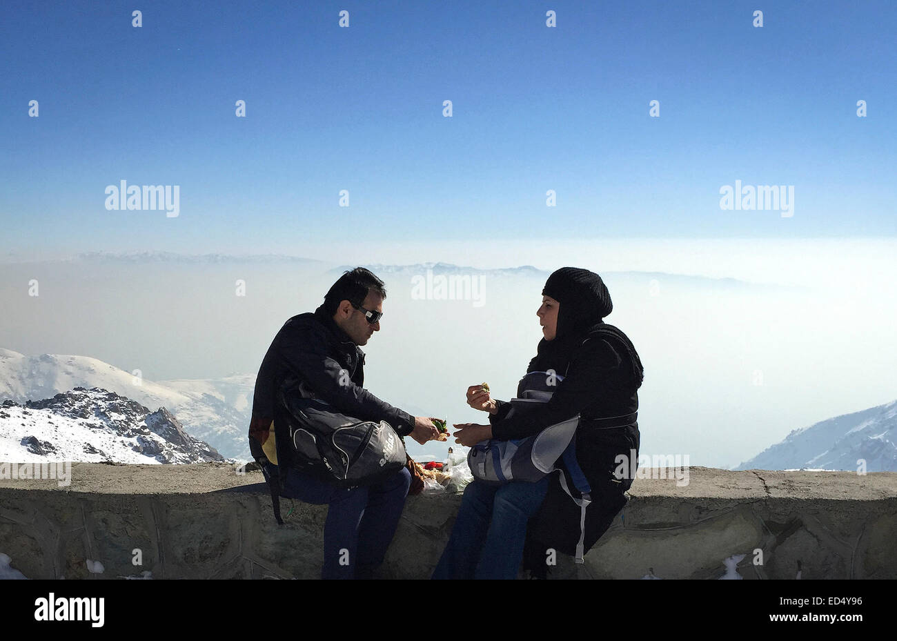 Tehran, Iran. Il 26 dicembre, 2014. Foto scattata da un iPhone mostra un giovane iraniano di avere la prima colazione presso la Tochal ski resort nel Nord di Teheran, capitale dell'Iran, del 26 dicembre 2014. Iraniani gregge alle stazioni sciistiche intorno a Teheran per l'inverno piacere dopo una nevicata ha colpito la città capitale. © Ahmad Halabisaz/Xinhua/Alamy Live News Foto Stock